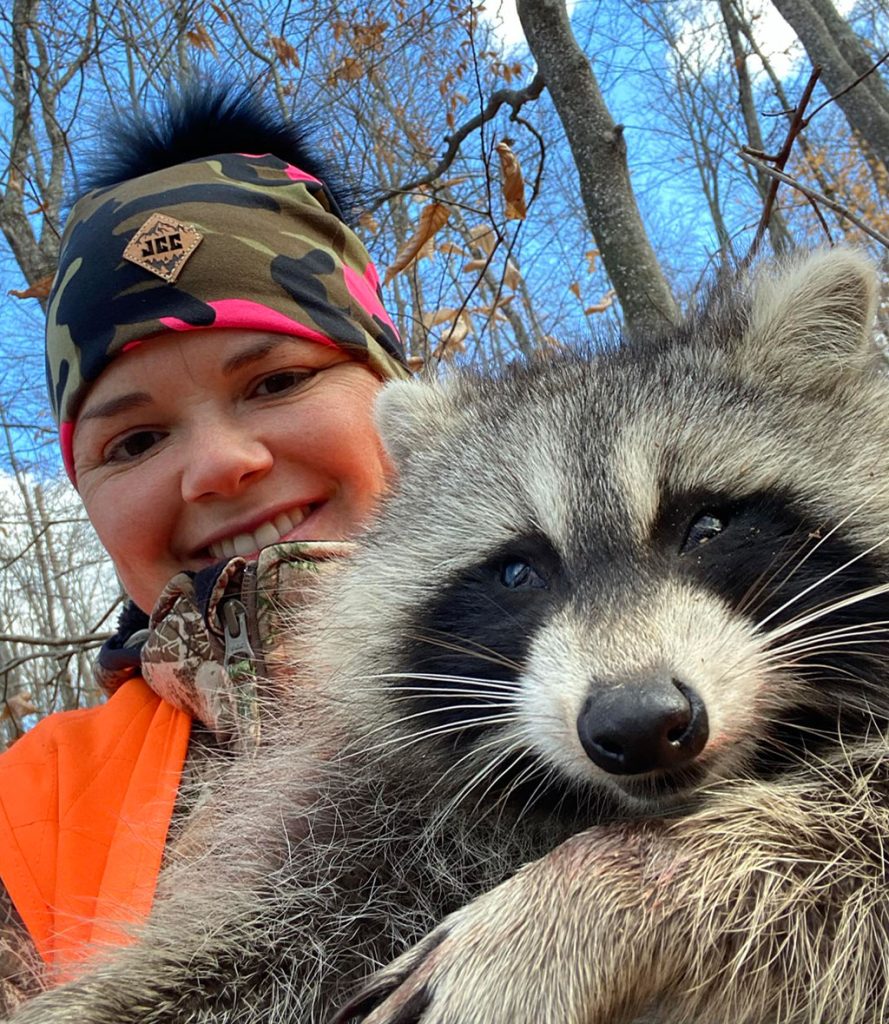 female trapper with raccoon